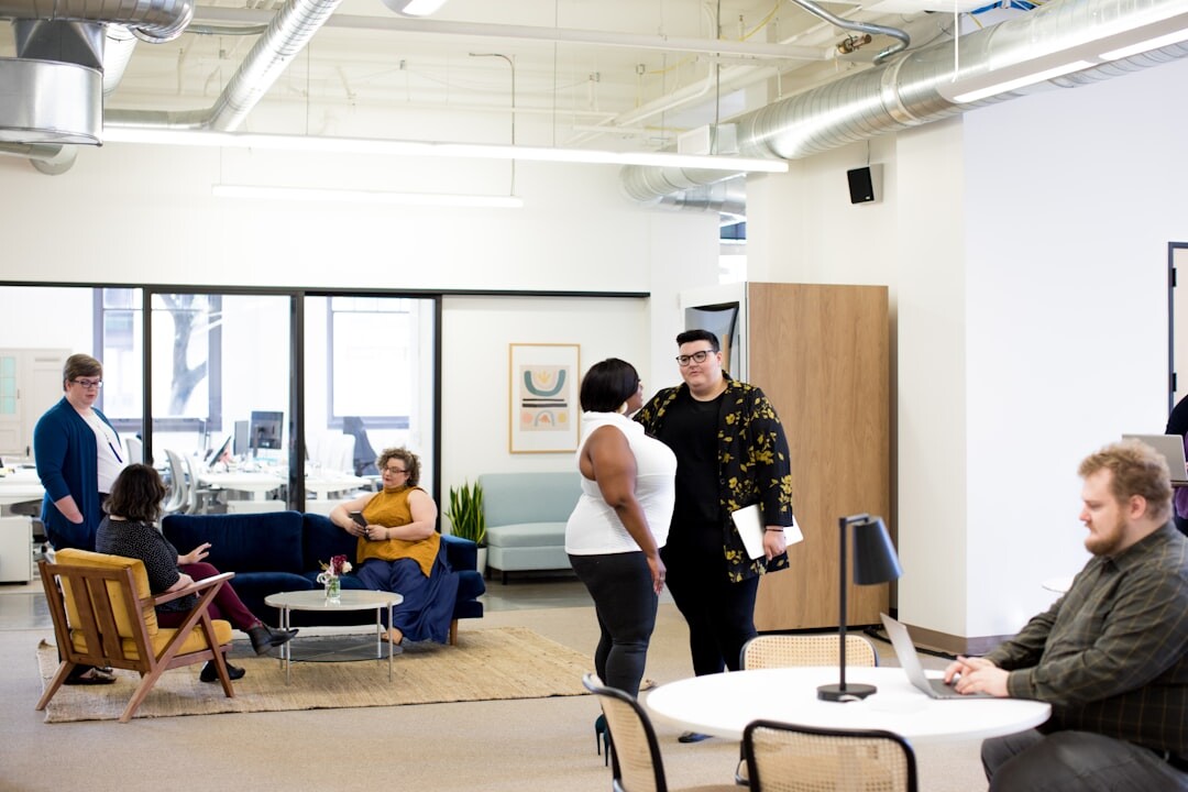 Young startup team collaborating around laptops in a modern office